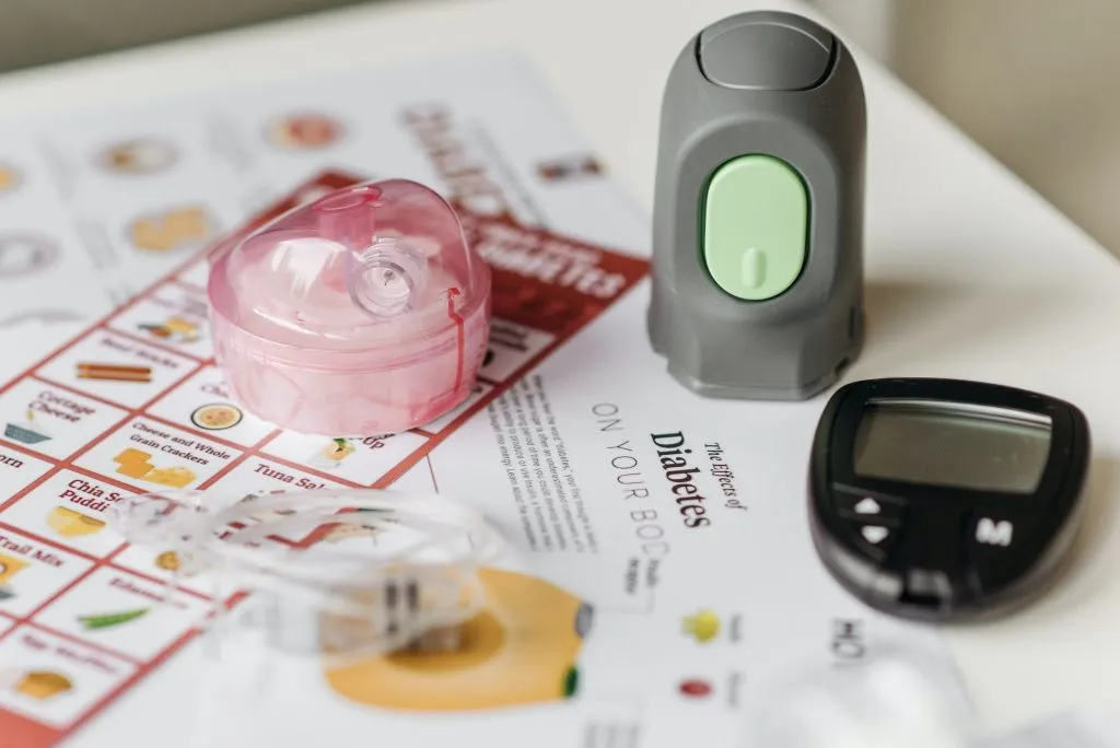 Diabetes kit with blood sugar level detector over informative papers.jpg